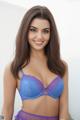 A woman in a blue bra and purple panties posing for a picture.