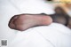 A close up of a person's foot on a bed.