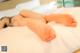 A woman laying on top of a bed with her feet up.