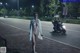 A naked woman walking down the street at night.